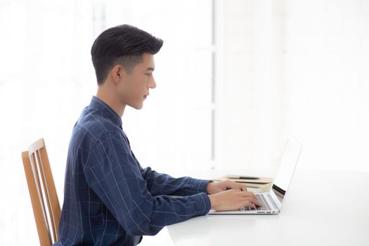 Young business man working from home with laptop computer on desk, freelance male sitting stay home using notebook for communication and relax on table, entrepreneur in startup business, new normal.