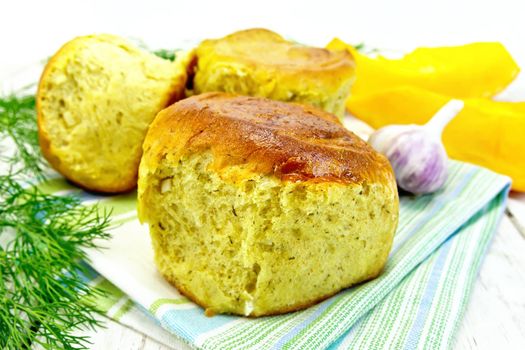 Pumpkin Scones with garlic and dill on a towel, yellow pumpkin slices on the background of wooden boards