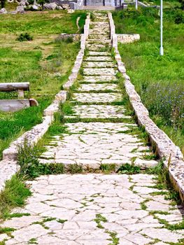 Ancient staircase made of natural stone with green grass