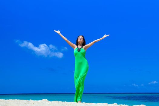 Happy smiling woman enjoy vacation on beach with raised hands