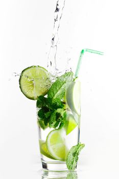 Making mojito cocktail with lime and mint isolated on white background