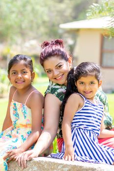 Love between a young mother and her two pretty daughters outdoors