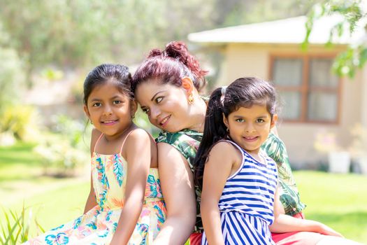 Love between a young mother and her two pretty daughters outdoors