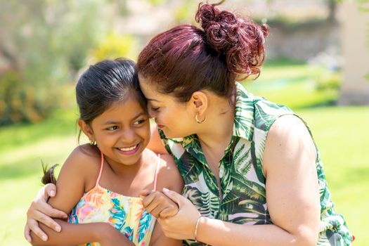 Love between a young mother and her pretty daughter outdoors