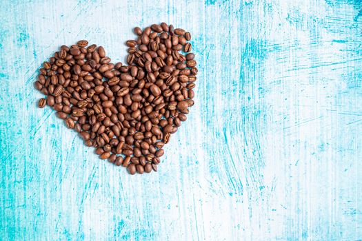 Heart shaped coffee grains on aquamarine background