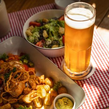 Beer mug with salad and meat meal