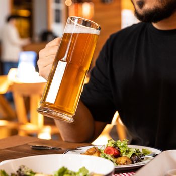 Man drinking beer with salad
