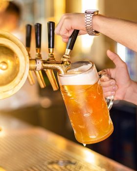 Man pouring, filling beer glass, mug