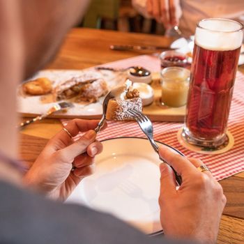 Man eating jam sweet dessert with dark, black beer