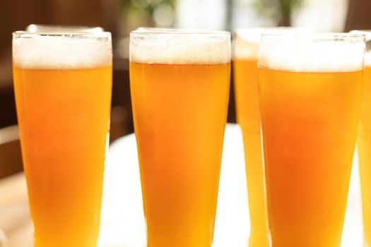 A lot of beer drink glasses, mugs on the table, sun shine, glass shadow