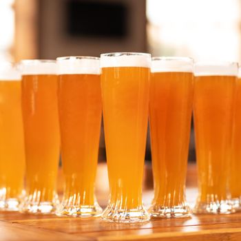 A lot of beer drink glasses, mugs on the table