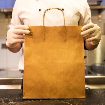 Chef holding food delivery bag