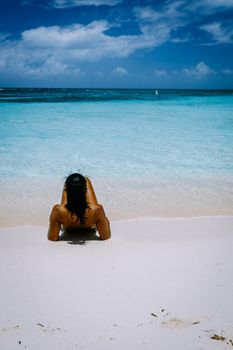 Palm Beach Aruba Caribbean, white long sandy beach with palm trees at Aruba Antilles, couple man and woman mid age on a white beach with palm trees