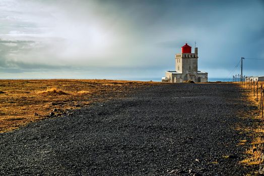 Dyrholaey lighthouse at sunset in a cloudy day, Iceland