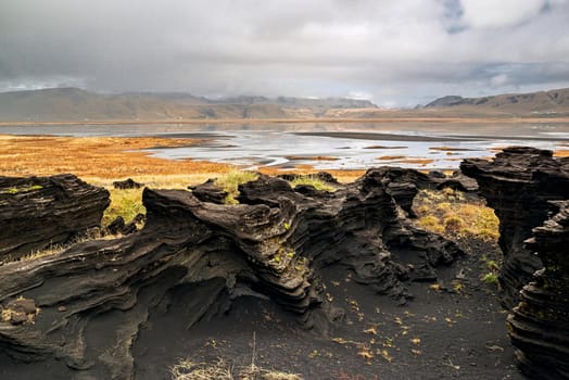Volcanic rock formation near Dyrholaey in a cloudy day, Iceland