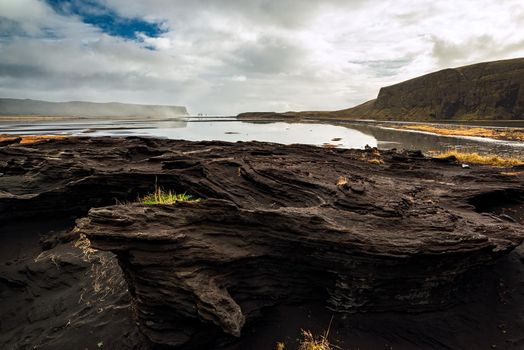 Rock formation on a black volcanic beach at Dyrholaey, Iceland