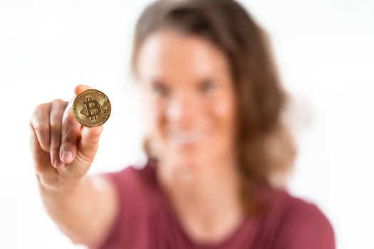 bitcoin coin in the hand of a young attractive business woman.