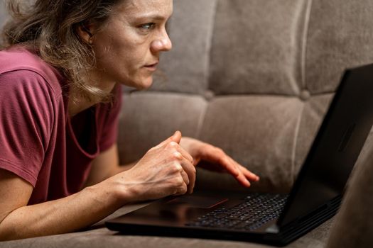 work at home freelance. young woman working with laptop on the couch.