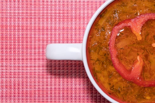 tomato soup in a mug on a red background top view. High quality photo