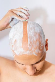 Man Shaving His Head Using White Foam