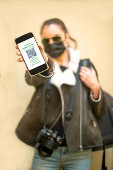 young person holding a spartphone showing the coronavirus immunity certificate