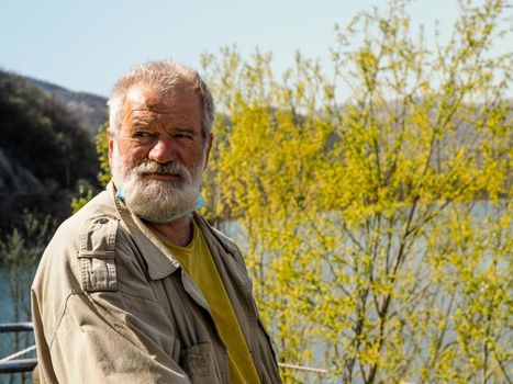 senior man breathe and relax outdoors near a lake