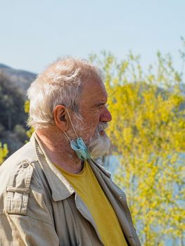 portrait of an active senior adult man at the lake breathing and relaxing outdoors