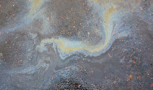 Oil stain on asphalt as texture or background.Environmental pollution concept.