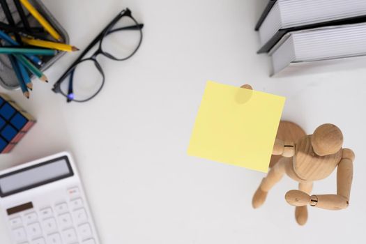 Yellow sticky notes and business tools on white wooden desk. top view