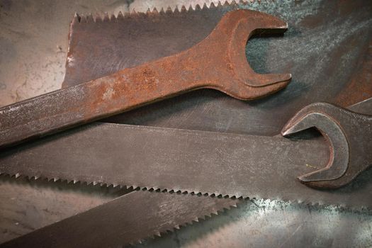 wrenches and hacksaw blades lie on a metal sheet