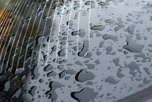 Drops of water on rear car window, heating stripes visible. Soft selective focus