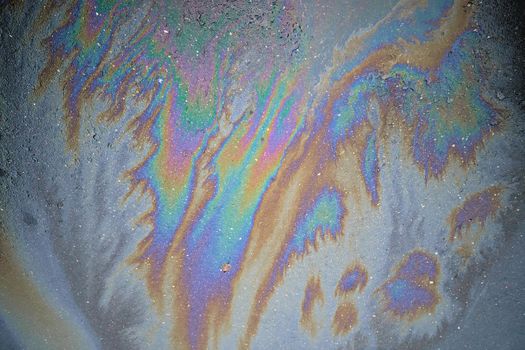 Beautiful abstract colorful background, texture, stains from engine oil on the asphalt.Colorful gas stain on wet asphalt