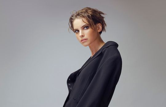 Beautiful stylish woman wearing black jacket. Fashionable and self-confident girl. Clothing, style and fashion