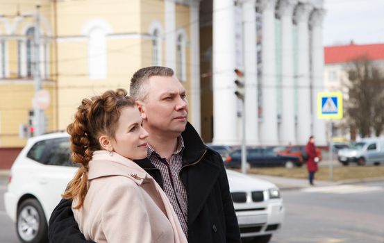 married couple walking along a city street on spring day