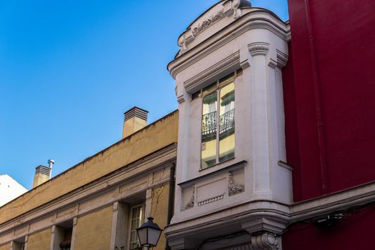 White balcony next to yellow and red walls