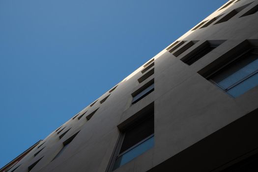 White building in Madrid with several windows and seen from below