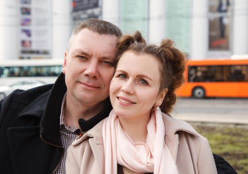 married couple walking along a city street on spring day. portrait closeup