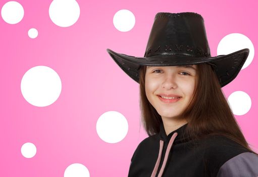 teenage brunette girl posing with black hat in studio on pink background