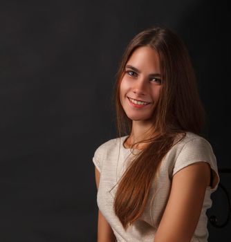 portrait of a young beautiful smiling girl in studio on a black background