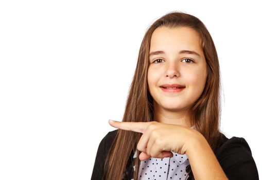 positive beautiful brunette teen girl with long hair pointing to the side . presenting your product. isolated on white background