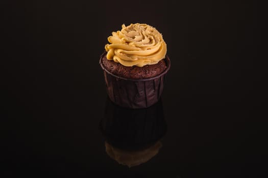 Peanut Butter Cupcake On A Black Background With Reflection.