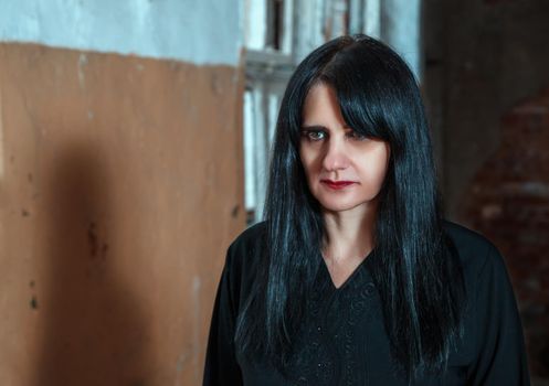 portrait of young goth woman in an abandoned building. indoor closeup