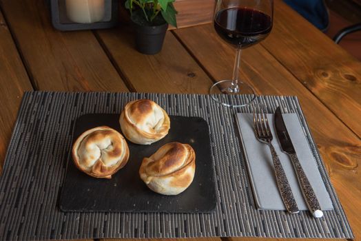 Homemade empanadas with a black stone plate.