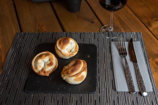 Homemade empanadas with a black stone plate.