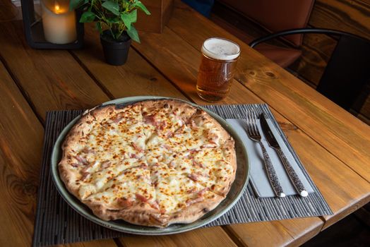 Pizza with beer and wooden background.