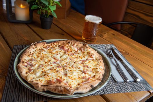 Pizza with beer and wooden background.