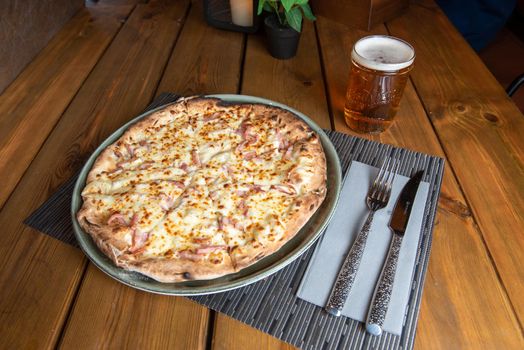 Pizza with beer and wooden background.