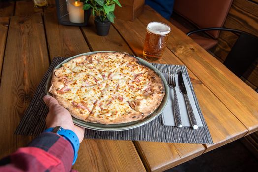 Pizza with beer and wooden background.