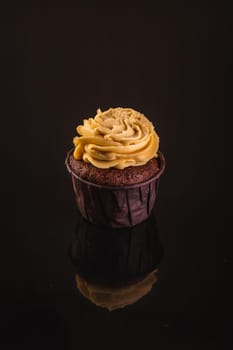 Peanut Butter Cupcake On A Black Background With Reflection.