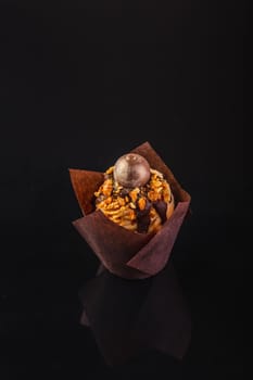 Peanut Butter Cupcake On A Black Background With Reflection.